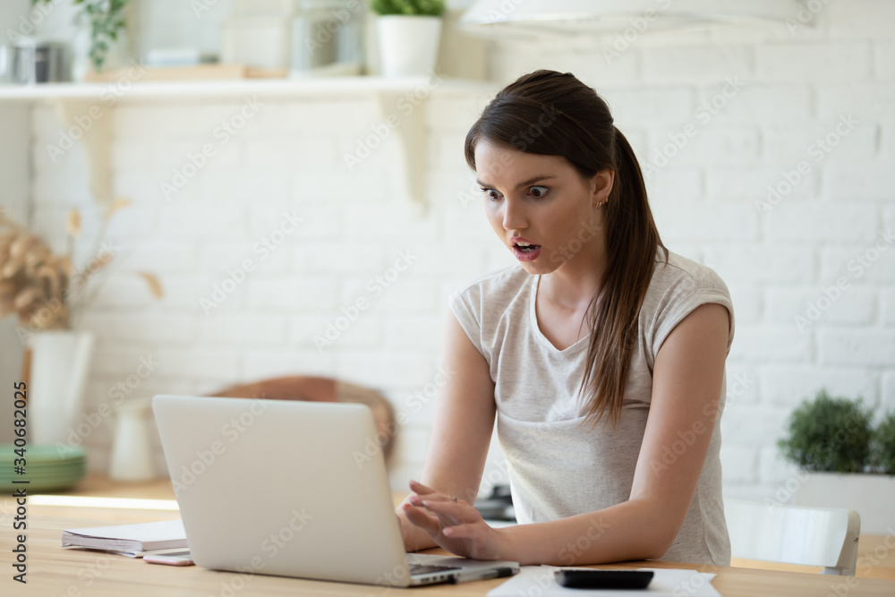 Shocking young woman using calculator and laptop for calculating finance rates looking at screen. Girl accounting with check credit analytic for mortgage payment. Wow and amazing emotion concept. Shocking young woman using calculator and laptop for calculating finance rates looking at screen. Girl accounting with check credit analytic for mortgage payment. Wow and amazing emotion concept.