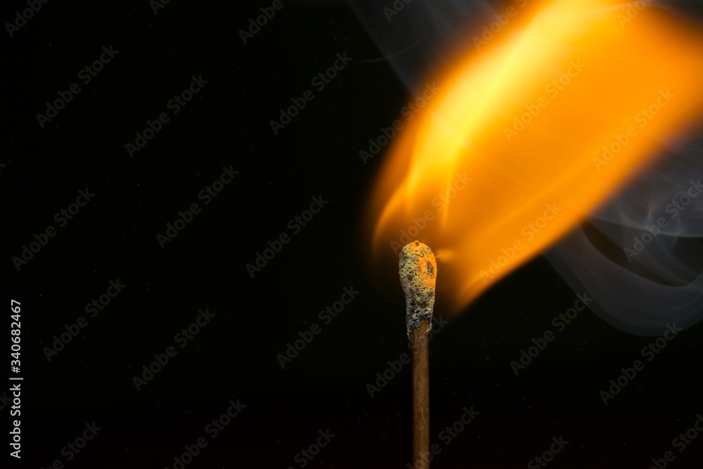 burning match on black background burning match on black background