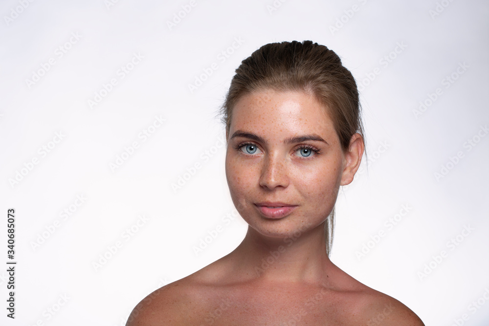 Beautiful girl with freckles shows emotions in front of the camera on a white background Beautiful girl with freckles shows emotions in front of the camera on a white background