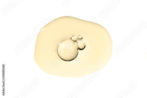 Cosmetic serum smear smudge golden swatch with collagen and peptides. Skin care gel transparent sample golden drop with bubble isolated on white. Emulsion texture. Anti aging woman cosmetic product.