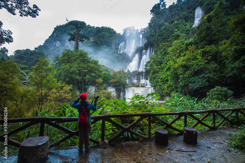 The girl in blue sweater touring on Thi-Lo-Su waterfall, Beautiful waterfall in Tak province, ThaiLand.