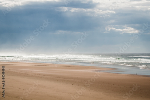 Magnifique plage en bord d'océan, un jour de grisaille