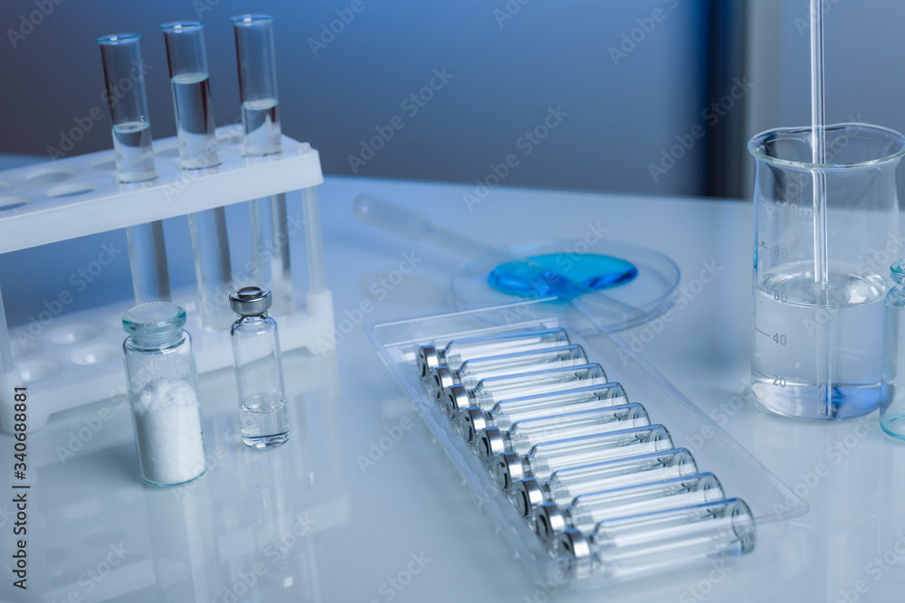 bottles with liquid medicine on a table in a laboratory. laboratory testing of antiviral drugs bottles with liquid medicine on a table in a laboratory. laboratory testing of antiviral drugs
