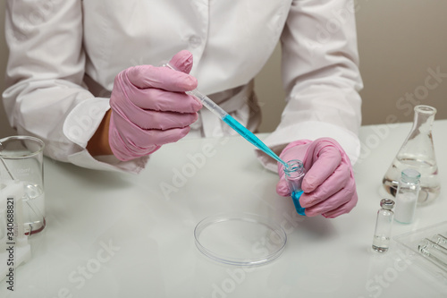 production of vaccine against virus . scientist's hands in gloves are conducting chemical experiments in lab. chemist works with lab glassware close up © Петр Смагин