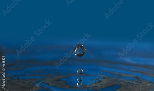 Three luscious blue falling droplet to water surface