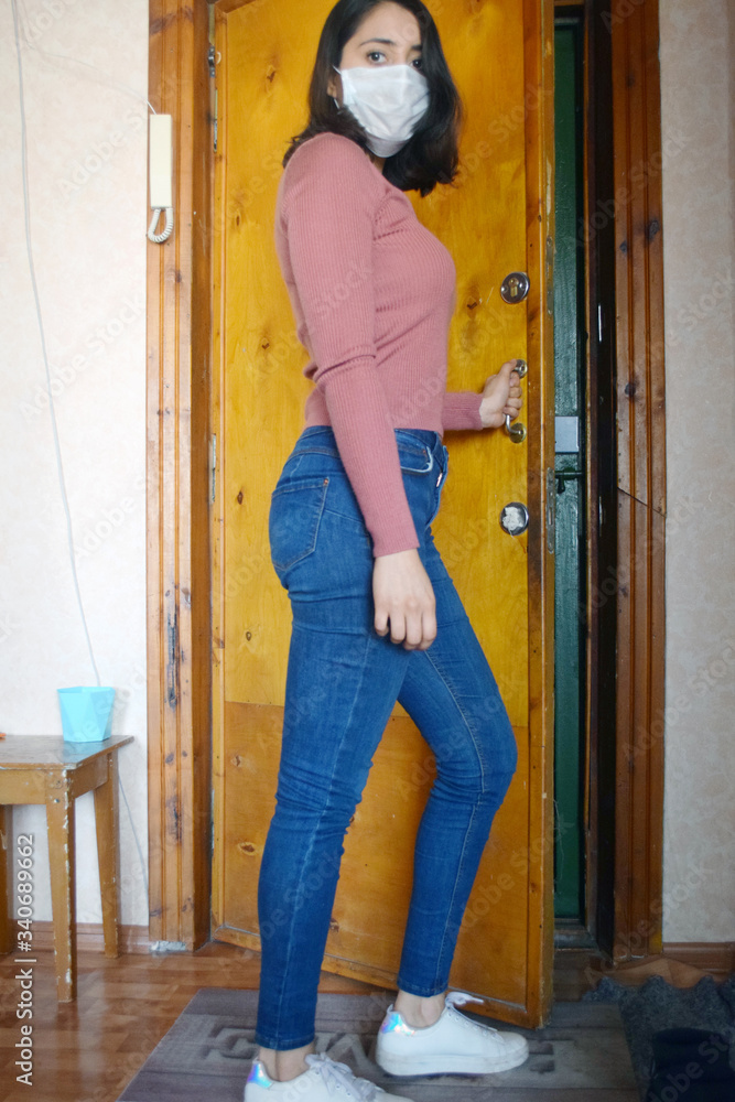 young woman with face mask opening a door young woman with face mask opening a door