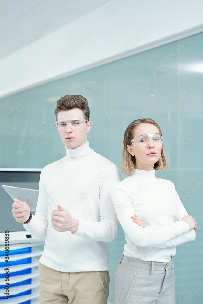 Obraz premium Two young serious modern technologies center consultants in white jumpers