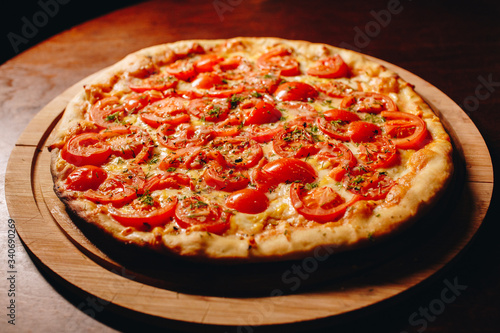 Stock Photo - Fresh delicious Italian pizza on a dark background