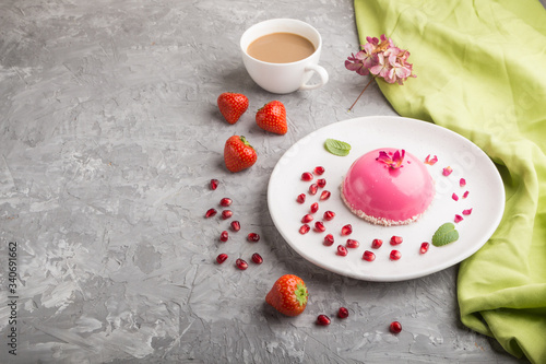 Pink mousse cake with strawberry  and a cup of coffee on a gray concrete background. side view, copy space.