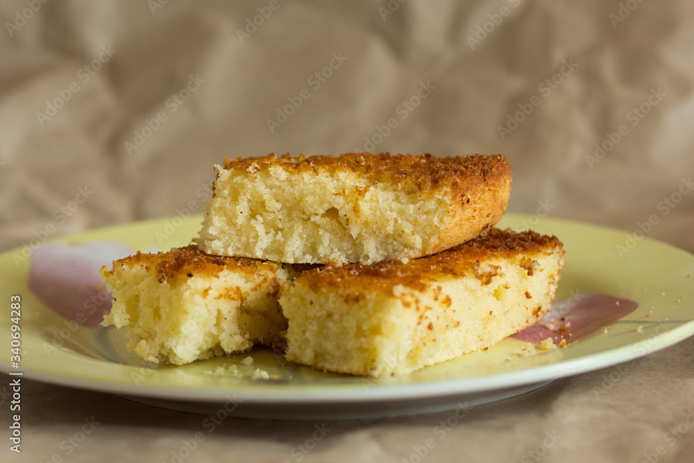 Pieces of baked mannik semolina casserole on yellow plate Pieces of baked mannik semolina casserole on yellow plate