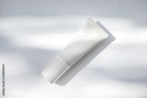 Mockup de frasco de crema hidratante blanco con sombras naturales photo
