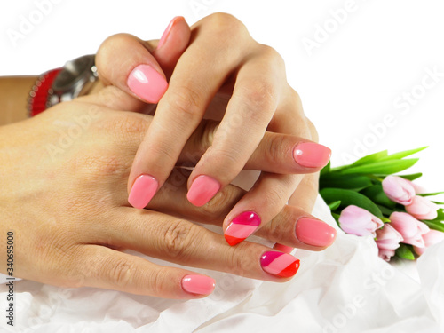 Beautiful pink manicure with tulip flower on background