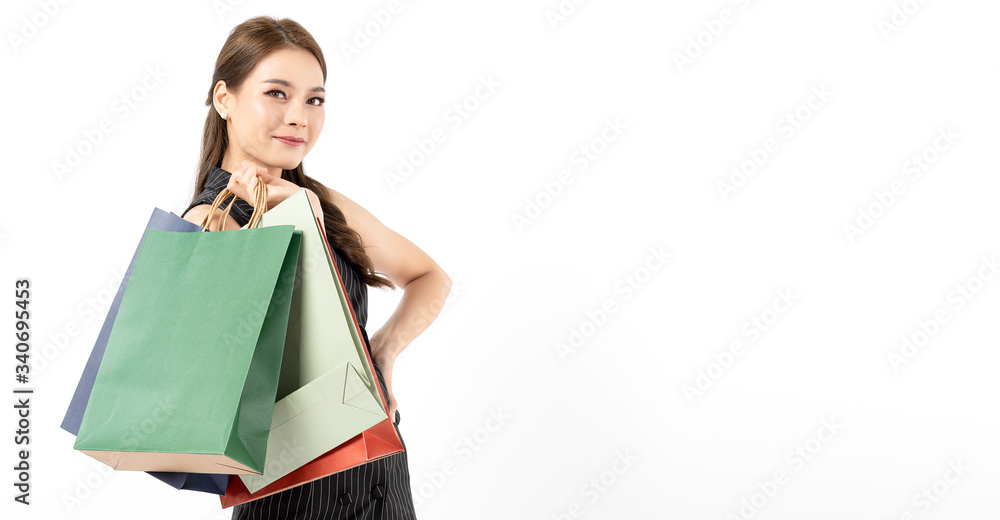 Portrait of young beautiful asian girl wearing black dress holding shopping bags and smile isolated over white background. Online shopping and black friday concept. Copy space for ypur text. Portrait of young beautiful asian girl wearing black dress holding shopping bags and smile isolated over white background. Online shopping and black friday concept. Copy space for ypur text.