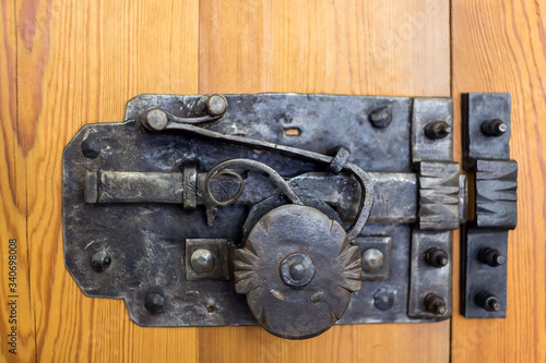 forged latch, lock on a wooden door, antiquity
