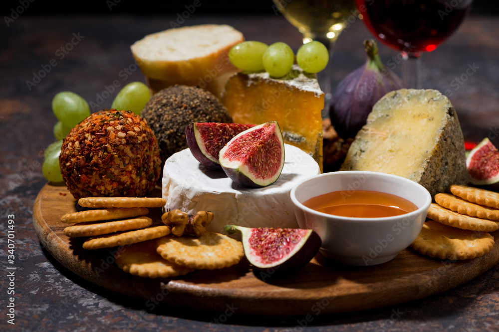 cheese, crackers and fruits, delicious wine snacks on dark background, closeup cheese, crackers and fruits, delicious wine snacks on dark background, closeup