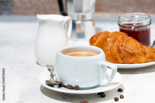 breakfast with espresso and croissants with jam, closeup