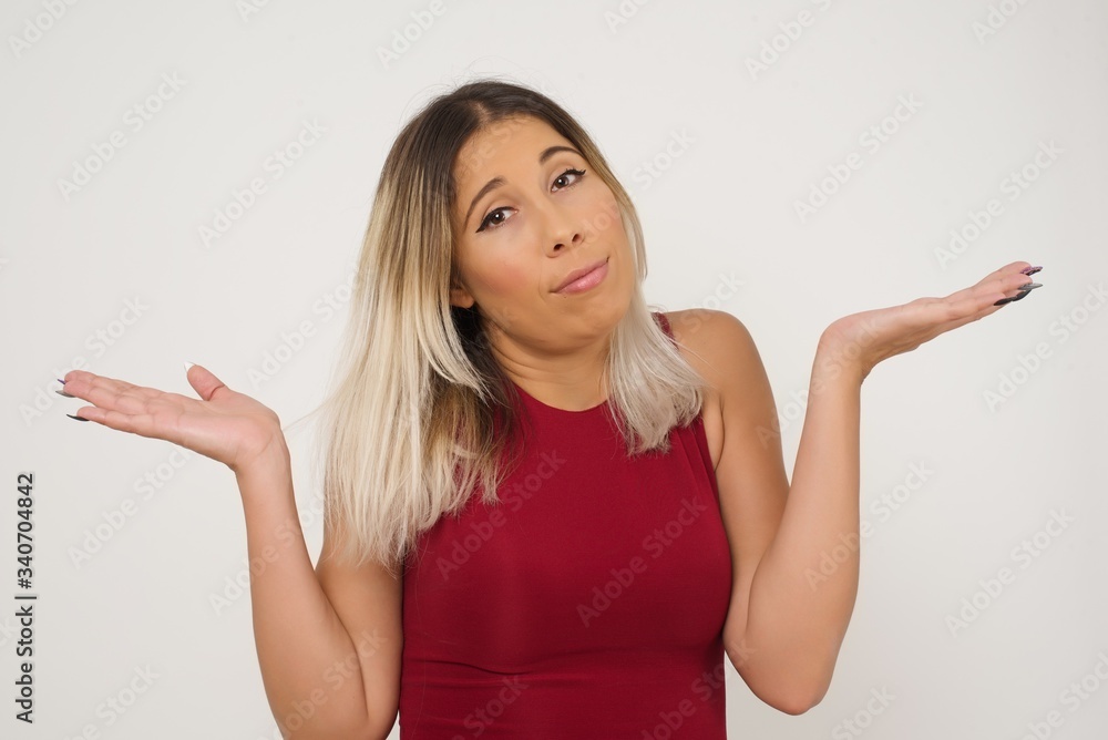 Beautiful woman doubt expression, confuse and wonder concept, uncertain future shrugging shoulders, standing against gray Wall. Beautiful woman doubt expression, confuse and wonder concept, uncertain future shrugging shoulders, standing against gray Wall.
