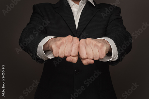 businessman clench two fists together. Place for letters on fingers. Gesturing power.