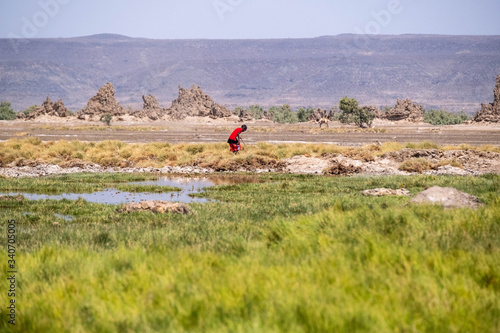 A nomadic child is walking around lake Abbe with a stick