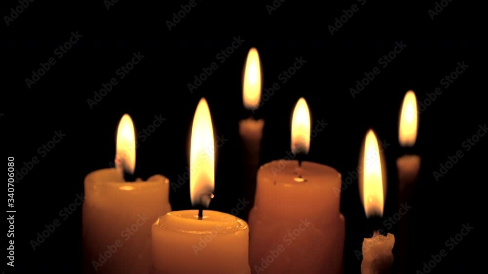 Candles burning on black background. Candle flame isolated on black background. Flames sway in the wind from the draft. Closeup, macro, close-up Candles burning on black background. Candle flame isolated on black background. Flames sway in the wind from the draft. Closeup, macro, close-up