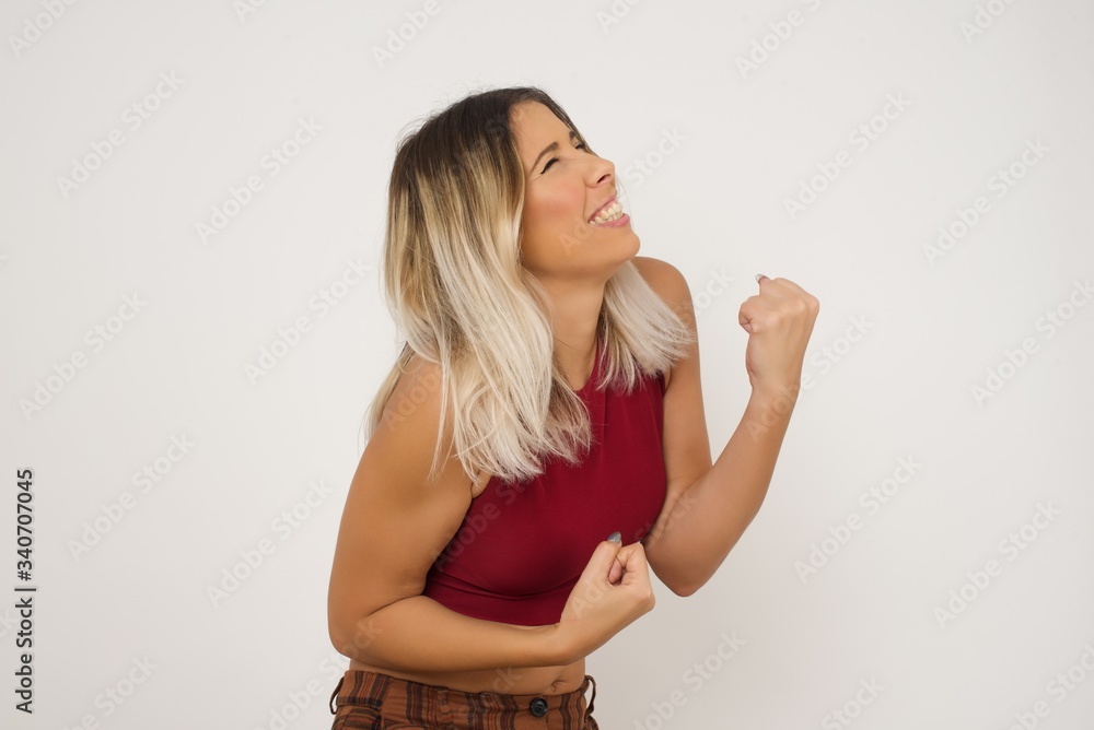 Caucasian brunette woman rejoicing her success and victory clenching her fists with joy. Lucky woman with hair bun being happy to achieve her aim and goals. Positive emotions, feelings. Caucasian brunette woman rejoicing her success and victory clenching her fists with joy. Lucky woman with hair bun being happy to achieve her aim and goals. Positive emotions, feelings.
