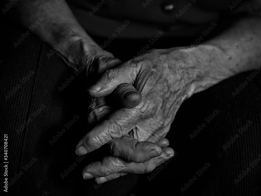 Elderly woman folded her hands on her knees
