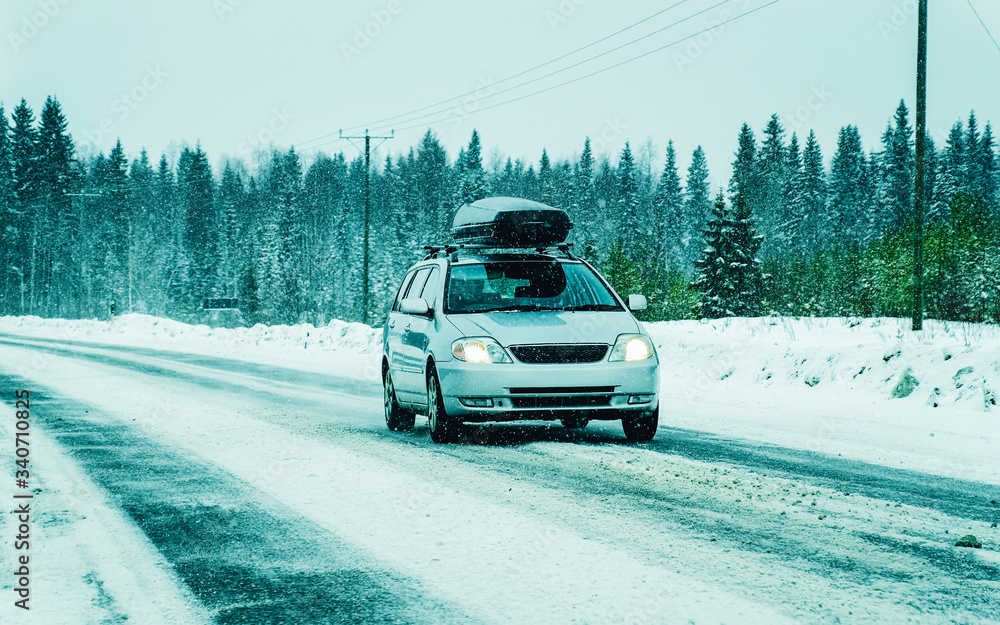 Car with roof rack in winter snowy road in Rovaniemi reflex