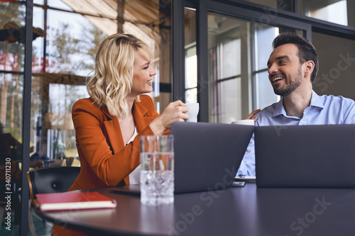 Stylish blonde young manager encouraging her coworker