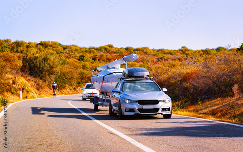 Car with yacht or motor boat at road of Sardinia reflex