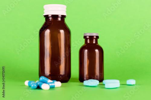 Medicine glass bottle with vitamins and blue capsules