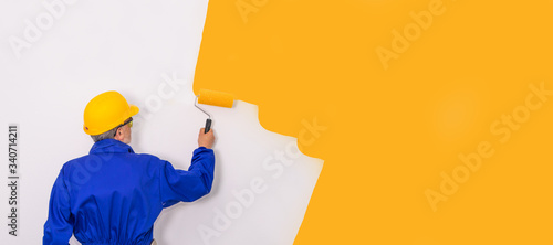 painter with brush painting the wall with work clothes photo