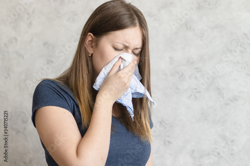 Fotografia Sick woman with handkerchief sitting at home with flue, virus, cold, seasonal allergy symptom