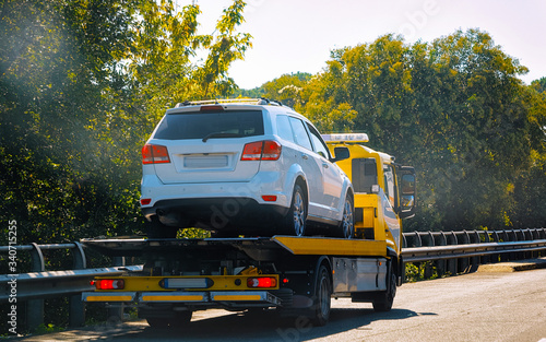 Tow truck with car on road reflex