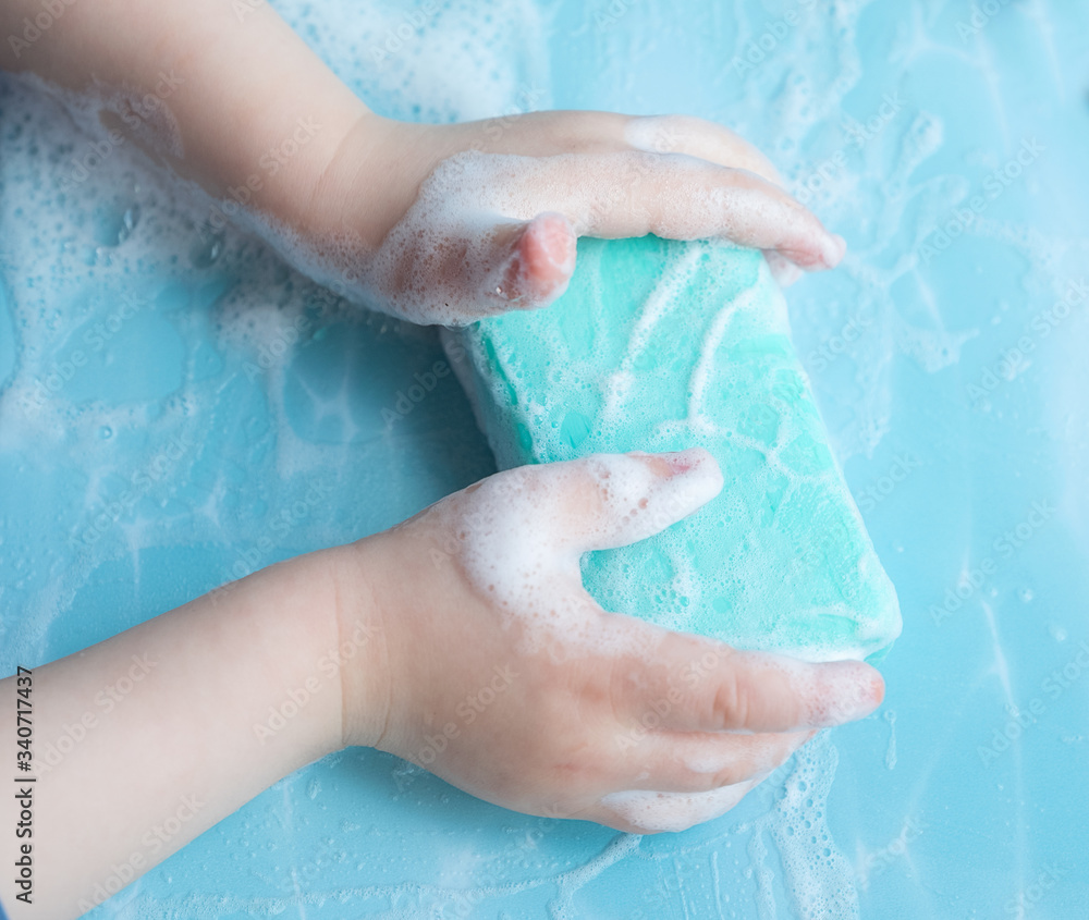 Fototapeta premium Soap with children's hands and foam, top view 