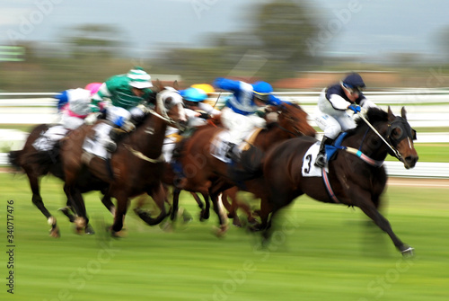 Horse Racing at race track motion blur as jockey fights exciting contest for victory