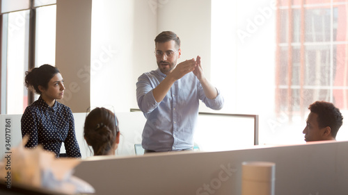 In modern shared space gather together businesspeople diverse employees listen ceo company boss executive give speech explain to staff corporate goals search solutions together during briefing concept photo