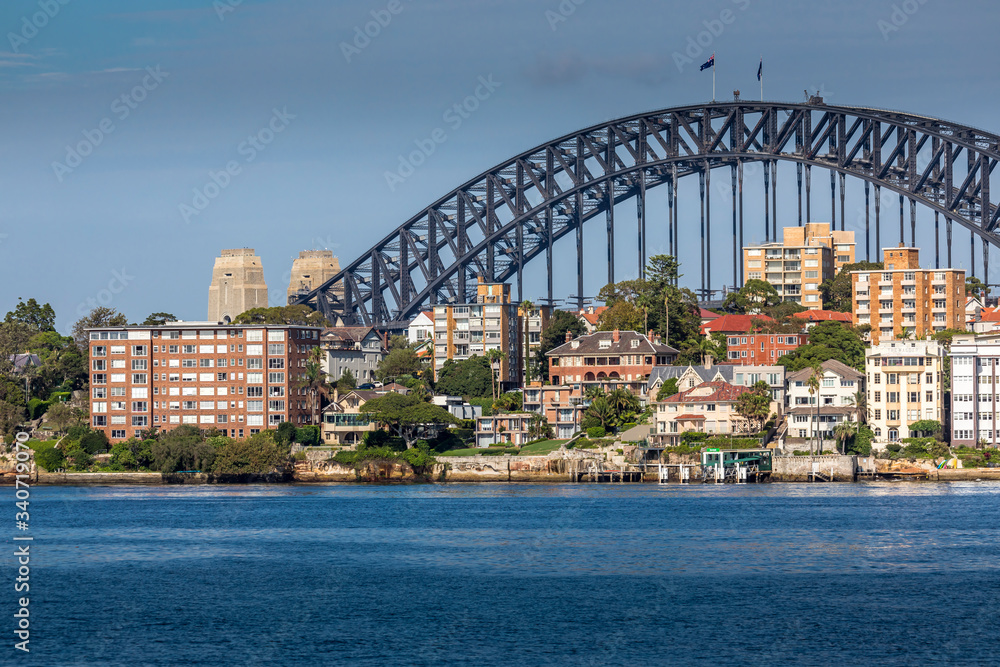 Fototapeta premium Sydney, Australia - 10th February 2020: A German photographer visiting Sydney in Australia, taking pictures of the skyline with the Harbour Bridge during a cloudy but warm day in summer.