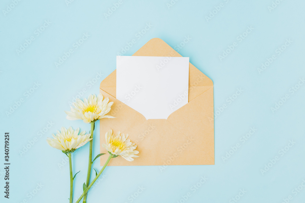 Mockup white greeting card  and envelope with flowers on a blue background
