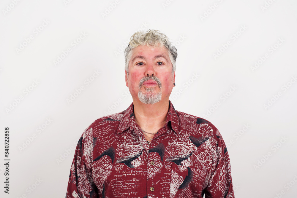 Attractive light haired male rounds lips, wears casual clothes, looks directly into camera, expresses her satisfaction, isolated over gray background. People, body language concept†Attractive light haired male rounds lips, wears casual clothes, looks directly into camera, expresses her satisfaction, isolated over gray background. People, body language conceptâ€
