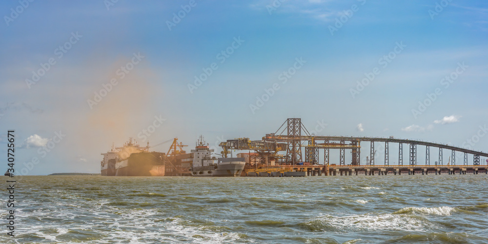 Loading bulk carrier ships with bauxite aluminum ore at Kamsar port, Guinea.