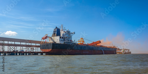 Loading bulk carrier ship with bauxite aluminum ore at Kamsar port, Guinea. photo