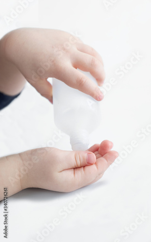 Children's hands and disinfectant, on a white background. 