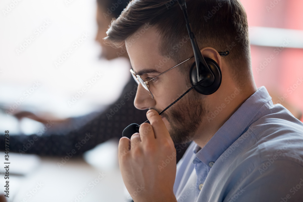 Fotografie Close up call center worker side view face touch mic chatting with client use mi