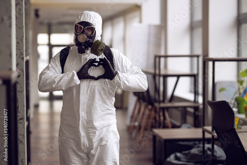 Cleaning and Disinfection at town complex amid the coronavirus epidemic. Professional teams for disinfection efforts. Infection prevention and control of epidemic. Protective suit and mask