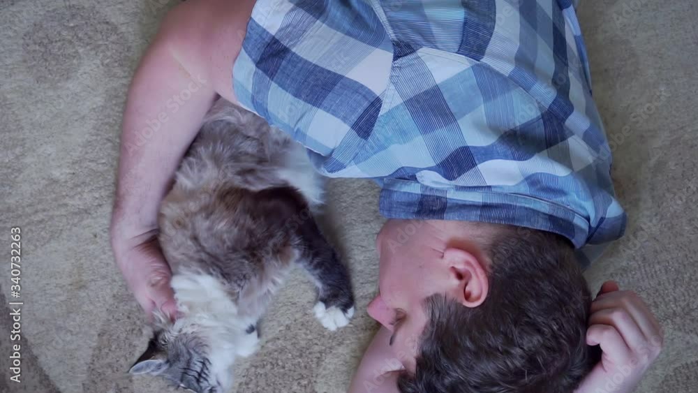 man is resting lying on the floor with his beloved cat man is resting lying on the floor with his beloved cat