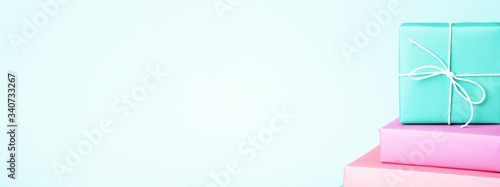 Set of pastel colored gift boxes on turquoise background. Minimal styled bann...