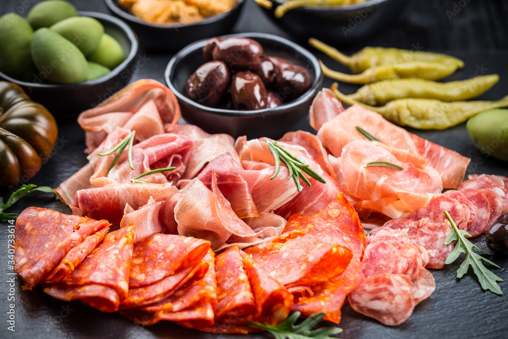 Platter of antipasti with a mixture of salami, prosciutto, bocconcini, peppers, tomatoes and olives