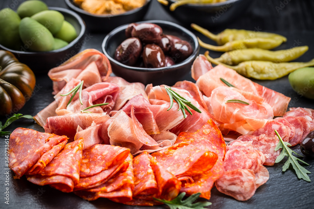 Platter of antipasti with a mixture of salami, prosciutto, bocconcini, peppers, tomatoes and olives Platter of antipasti with a mixture of salami, prosciutto, bocconcini, peppers, tomatoes and olives