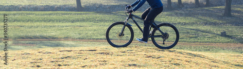 Cyclist in pants and fleece jacket on a modern carbon hardtail bike with an air suspension fork. The guy on the top of the hill rides a bike.