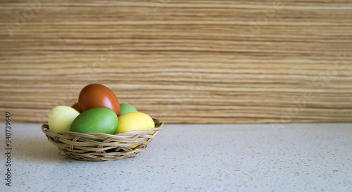 Easter colored eggs in a wicker plate.